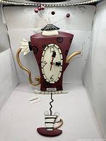 Full view of teapot clock with teacup pendulum attached