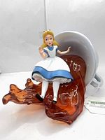 Full view of figurine showing Alice on tea spill
