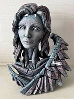 Front view of textured grey angel bust sculpture with fragmented wing detail