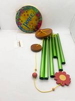 Full view of wind chime with header, tubes, striker, flower sail, hang tag visible