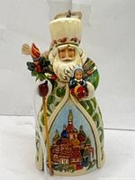 Front view of Jim Shore Russian Santa ornament holding staff and nesting doll