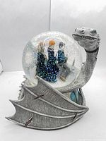 Frontal view of dragon water globe showing figures inside and wing detail