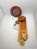 Full wind chime laid out with tubes, plaque, flower sail, tag visible