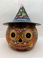 Front view of Jim Shore Day of the Dead Jack-O-Lantern showing sugar skull face and LED eye inserts