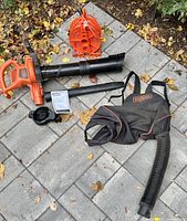 Complete set laid out: blower body, two tubes, cord reel, backpack bag with hose, manual