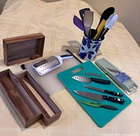 Group view showing all items including knives, boards, mandoline, grater, holder, utensils, drawer inserts