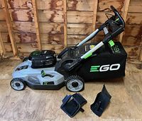 Left side view of mower with bag, mulching plug and side discharge chute visible