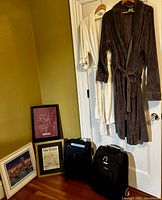 Overview showing both robes, framed prints and two suitcases