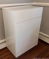 Front three-quarter view of chest showing glossy finish and linear design