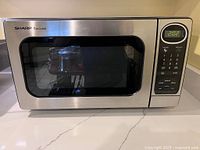 Front view of Sharp Carousel stainless microwave showing stainless exterior and glass door