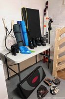 Wide view showing skis, poles, boots, mats, racquets, binoculars, step platform, baseball gloves