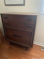 Front view of four-drawer MCM highboy dresser with recessed pulls and sculpted base