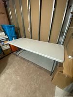 Full view of rectangular plastic folding table, legs extended