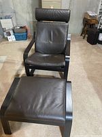 Front view of brown leather Ikea Poäng armchair and matching footstool