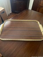 Top view of rectangular faux wood tray showing wood grain surface and gold-tone rim