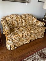 Front angled view showing overall loveseat form, upholstery and skirt