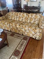 Front view of Sklar floral sofa showing full length, cushions, skirt and arms