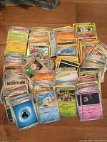 Stacks of assorted modern Pokémon cards spread on floor