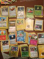 Stacks of mixed Pokémon cards spread out on table
