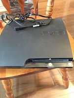 Top view of Sony PS3 console with power cord displayed