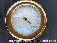 Front view of brass barometer showing dial and bezel