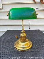 Front view of brass banker lamp with green glass shade