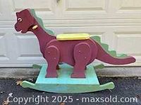 Full view of wooden rocking dinosaur showing color scheme and rocker base