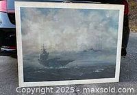 Full view of framed print leaning against car, shows overall artwork and frame