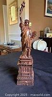 Front view of copper-tone metal Statue of Liberty on pedestal