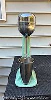 Full view of vintage Oster milkshake mixer with stainless cup on base