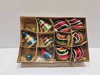 Boxed set showing all 12 glass ornaments sorted in compartments