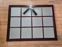 Full view of rectangular mirror showing 12 glass panels within dark wood frame
