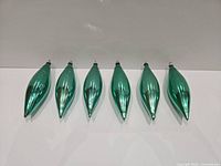 All six green glass ornaments aligned