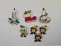 Group shot of all seven holiday brooches