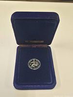Coin displayed inside blue velvet presentation case
