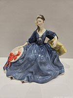 Front view of Elyse figurine showing blue dress and hat with red bow