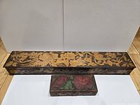 Both boxes closed, showing size difference and floral pyrography