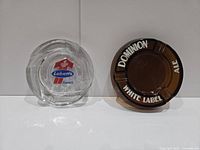 Both ashtrays side by side: clear Labatt's and amber Dominion