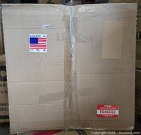 Sealed shipping carton bearing Made in USA and fragile labels likely containing the five tin ceiling tiles