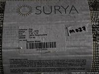 Close-up of Surya label showing collection, design, size, content, origin