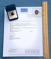 Ring in box atop appraisal alongside ruler showing scale