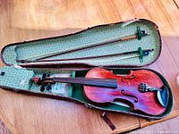 Open case with violin and two bows visible
