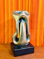 Full view of bronze abstract sculpture on black granite base