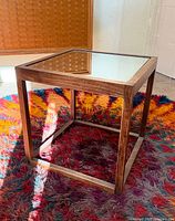 Three-quarter view of cube side table showing wood frame and mirrored top