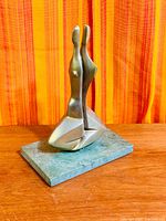 Front view of bronze couple sculpture on stone base