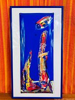 Full view of framed enamel artwork showing colours and framing