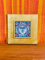 Full view of framed tile against background