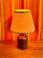 Full view of teak lamp with orange shade