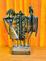 Full view of signed copper sculpture depicting couple with foliage on base