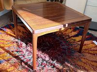 Three-quarter view of rosewood coffee table showing grain and tapered legs
